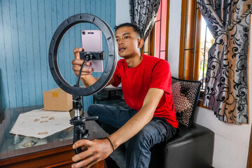 Portrait Young Asian Man As Content Creator Adjusting Ring Light Preparing For Social Media Content