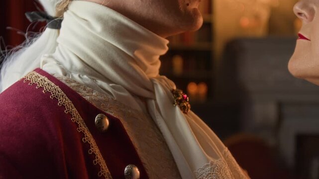 Close-up of anonymous loving young 18th century lord and lady in luxurious historical clothing embracing, while sharing intimate moment together before kissing