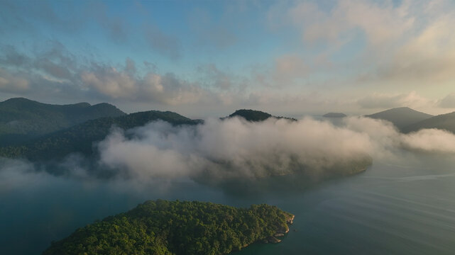 Aerial view of islands shrouded in ethereal clouds, where the lush green of the land meets the tranquil blue of the sea, Paraty, State of Rio de Janeiro, Brazil.