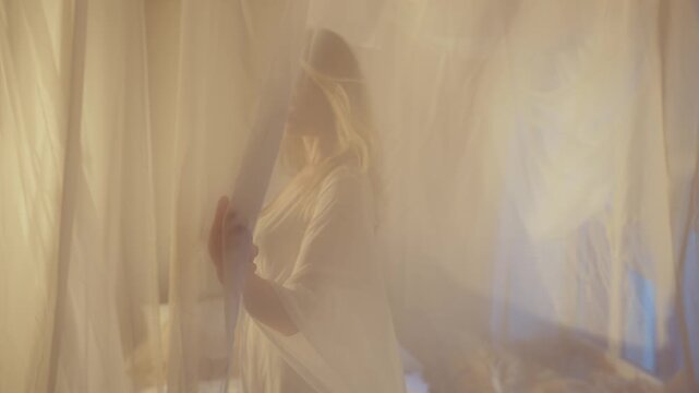 silhouette of woman walking through curtains, hand stroking transparent white silk fabric, fantasy blonde hair girl fashion model posing bride in seductive nightgown dress victorian vintage old style