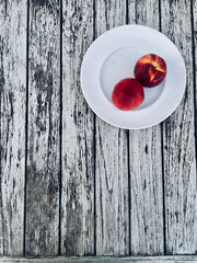 Fresh assorted fruits in the foreground on an old rustic wooden table. The colorful seasonal fruit arrangement creates a natural, healthy, and organic atmosphere
