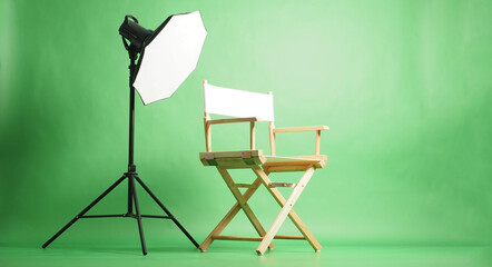 A white director chair and studio lighting setup on green screen background
