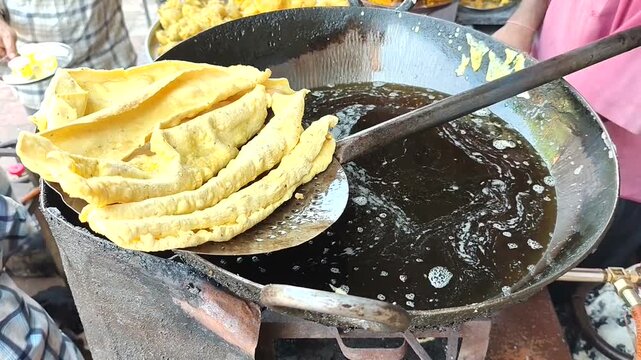 Fried Items like Fafda over a boiling pan  in rural area in India.