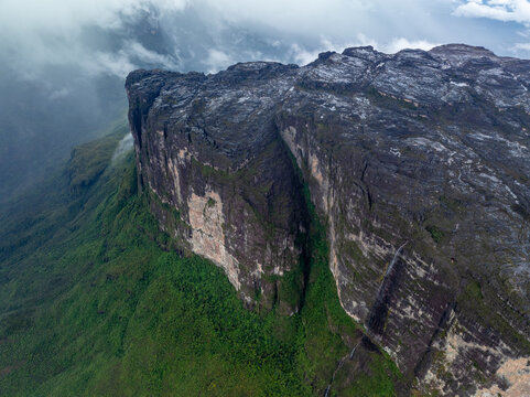 Aerial view of the majestic, flat-topped tepui rising dramatically from the dense green jungle, a testament to the ancient landscapes of Canaima National Park, Roraima, Canaima, Venezuela.
