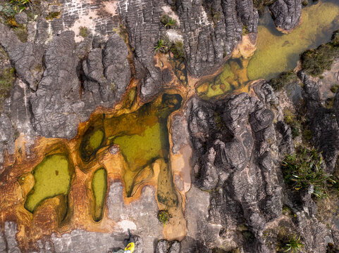 Aerial view of striking rock formations embrace pools of water, creating a tapestry of earthy tones, Roraima, Canaima, Venezuela.