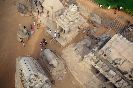 Mahabalipuram, India - 17 September 2006: Aerial view of Pancha Rathas and monolithic rock-cut temples gleam under the sun, contrasting with the soft hues of the sandy ground.