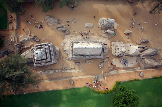 Mahabalipuram, India - 17 September 2006: Aerial view of the Pancha Rathas' monolithic temples stand as silent sentinels amidst the golden sands, framed by lush greenery.