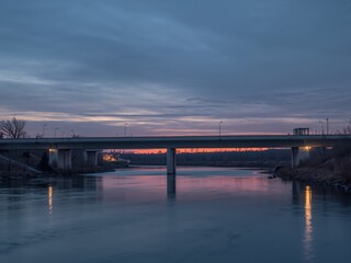 Twilight Passage. A Concrete Bridge in a Serene, CoolToned Waterscape, Reflecting Soft, Warm Light.