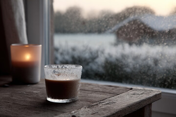 cozy winter morning captured through frosted window white snowflakes gently falling outside