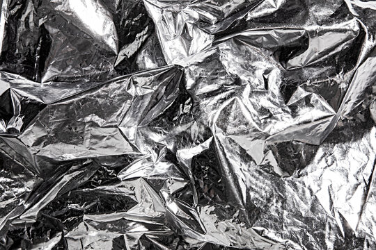 Abstract metallic foil background with crumpled and reflective surface