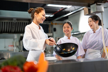 Professional chef is teaching young culinary class student to prepare fresh ingredient for the meal...