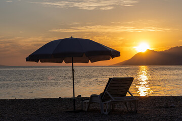 Beach umbrella and sun lounger at sunset on the Adriatic Sea, Croatia