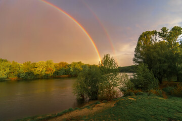 Obraz premium rainbow over the river and forest