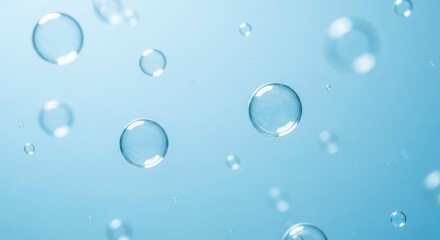 Transparent spherical bubbles of varying sizes float against a soft blue background Some bubbles are sharply defined showing clear reflections while others are gently blurred