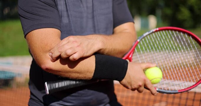 tennis elbow. male player with pain in his elbow joint during match. hand joint inflammation. sport injury