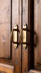 Obraz premium Closeup of vintage wooden cabinet doors with brass curved handles
