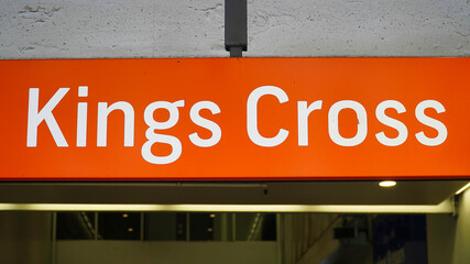 Fototapeta premium Kings Cross station sign brightly illuminated at night in London showcasing urban transit