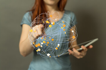 Close-up of a woman using a tablet to interact with a digital network visualization.