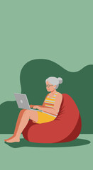 Content senior woman uses a laptop while relaxing on a comfortable beanbag chair. Illustrates modern aging, digital literacy, and leisure at home.