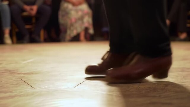 Close up of dancer feet in brown shoes performing traditional steps on a wooden floor