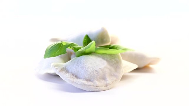 Frozen dumplings with herbs on a white background