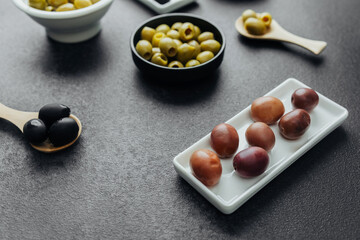Close view of assorted olive types, green, black and kalamata olives  on dark background
