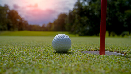 Golf ball is on a green lawn in a beautiful golf course with morning sunshine.