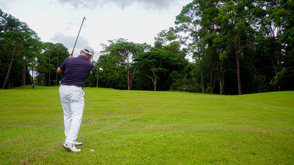 Golfer putting ball on the green golf, lens flare on sun set evening time.