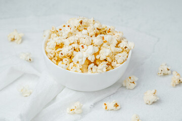 Bowl of freshly popped popcorn displayed on a white surface