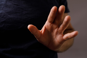 Obraz premium Close-up image of a hand making a stop gesture, symbolizing rejection, denial, or prohibition. Perfect for concepts related to boundaries, safety, and refusal.
