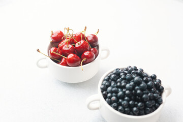 Bowls of raspberries, blueberries and cherries for fruit trio, diet or nutrition concept
