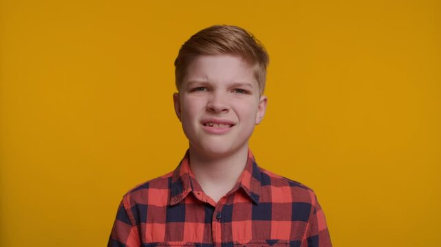 Boy Making a Disgusted Expression on Yellow Background
