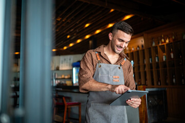 Man waiter with tablet in restaurant for a successful operation with digital tools, smart management