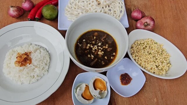 rice and vegetables Rawon is Indonesian traditional beef black soup,Original dish from East Java,served with steamed rice,boiled salted duck egg,chili sauce or sambal,bean sprouts and onion crackers