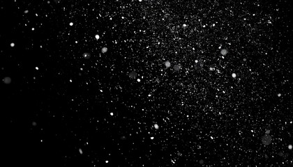 Abstract, dark background with a scattering of luminous particles, creating an illusion of snowfall or dust motes in the air. The effect is primarily white/gray against black