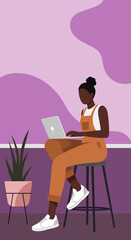 Focused woman in overalls using laptop on a stool, representing modern remote work, freelance, and digital productivity. Ideal for lifestyle, business, and technology content.