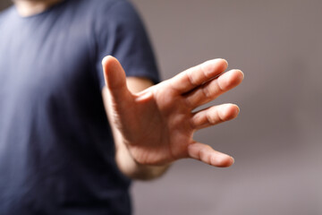 Close-up of a man's hand reaching forward, fingers slightly splayed.  Perfect for concepts of help,...