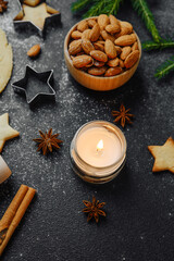 Cozy christmas baking with almonds and candle for warm holiday atmosphere and lifestyle concept