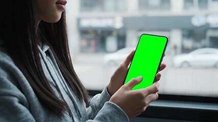 Woman driving car while using smartphone causing potential distracted driving hazard on busy city street