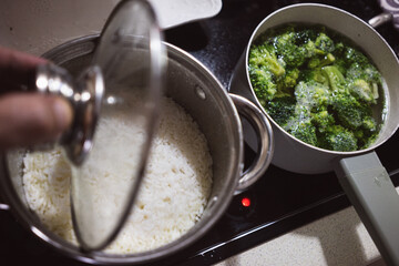 Rice and broccoli in pots on the stove