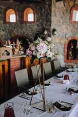 Photo of design, decor, table decorated with flowers and dishes for guests at a wedding celebration.