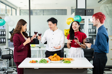 Coworkers gather around a modern office table, laughing and enjoying pizza, skewers, and wine, celebrating success in a fun and relaxed workplace setting.