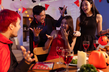Dinner and group of people celebrating together at Halloween party.