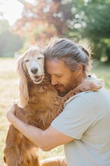 Man hugging his dog in the park