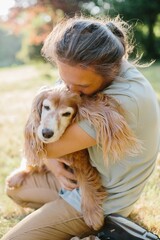 Man showing affection to his senior dog in a park