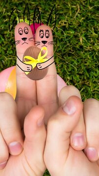Animation of hands with drawings of rabbit with easter egg over easter eggs on grass