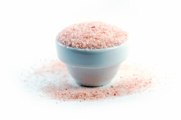 Pink Himalayan Salt in a clear glass bowl on a white background. Pink salt has more minerals that are beneficial to the body than regular table salt.