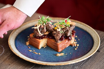 Traditional Czech dish — goose liver served on toasted bread, elegant restaurant presentation.