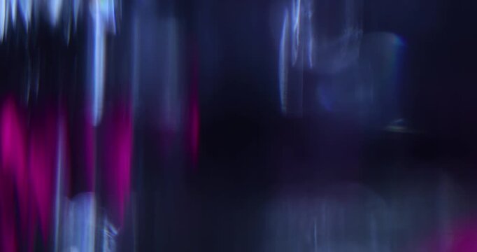 Abstract blurred light leaks on black background with copy space. Studio anamorphic lens flare bokeh effect.