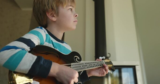Caucasian Kid Play Mandolin at Home. European Boy Practice Music 4K 10-bit